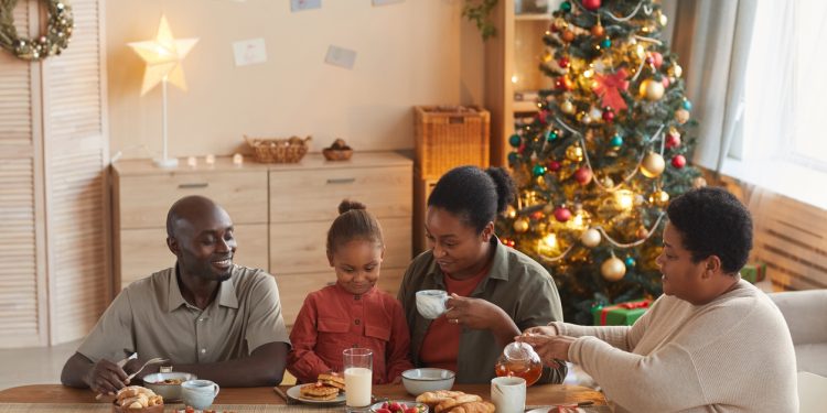 Family sharing breakfast on Christmas morning, reflecting mindful holiday wellness tips.