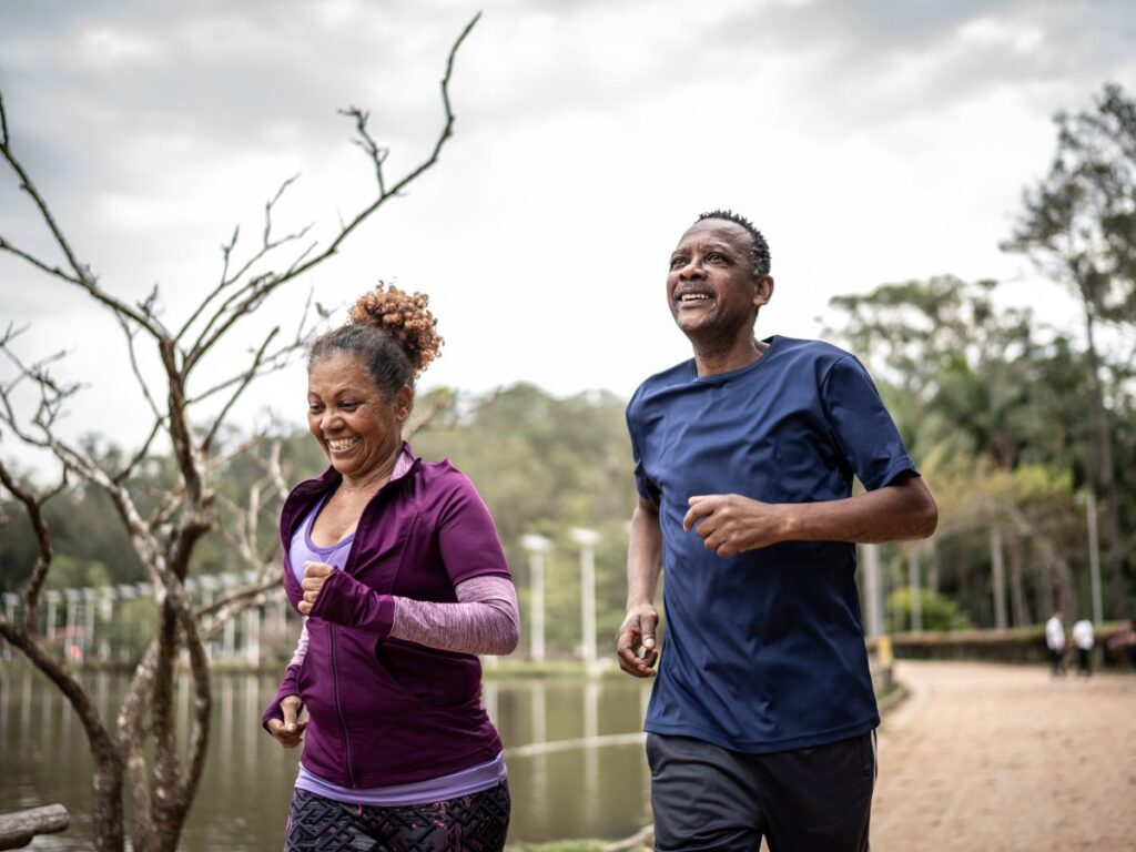 A couple jogging in a park to stimulate their parasympathetic nervous system and reduce stress.