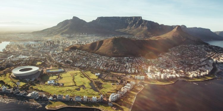 Aerial view of Cape Town showing Table Mountain, the city center, coastline, and Cape Town Stadium with surrounding urban areas and ocean