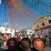 Colorful street decorations and wine barrels at Portugal wine festival in Madeira with crowds celebrating traditional harvest festival