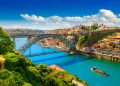 Colorful view of Porto, Portugal with the Dom Luís I Bridge crossing the Douro River on a bright summer day.