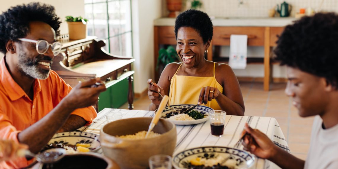 Afro-Brazilian family from the African diaspora enjoying a joyful home-cooked meal together.