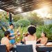 Friends sharing wine outdoors under a pergola, enjoying a relaxed garden meal. | wine travel guide 2025
